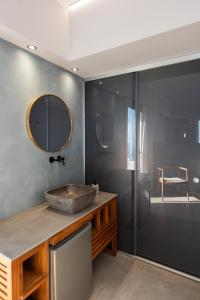 een badkamer met een stenen wastafel en een spiegel bij The Mini Beach Hotel in Stalós