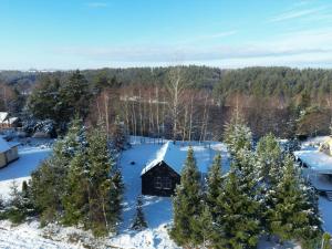 Activfarm domki na Kaszubach /domek Madzia في Lipnica: منظر هوائي لكابينة في الثلج