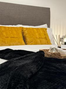 een bed met zwarte dekens en gele kussens bij Home away from home in Birmingham