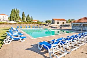 a row of lounge chairs next to a swimming pool at Lam Hotel Convento do Desagravo in Oliveira do Hospital
