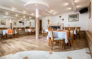 a restaurant with tables and chairs and a fireplace at Willa Górska Dolina Jacuzzi & Sauna in Poronin