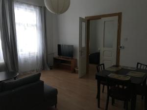 ein Wohnzimmer mit einem Esstisch und einem TV in der Unterkunft Apartmán u kostela in Turnov
