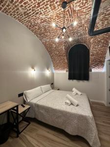 una camera con letto e muro di mattoni di CC Opera Suites a Madrid