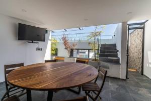 a dining room with a wooden table and chairs at Contemporary 4 bd house near Metropolitano park in Guadalajara