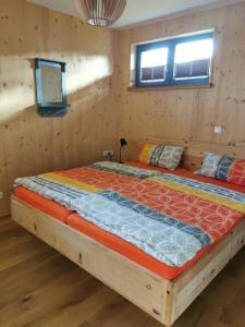 a large bed in a room with wooden walls at Ostseeseele in Parin