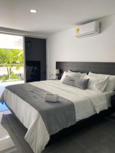 1 cama blanca grande en un dormitorio con ventana en Malokas Resort - Socorro - San Gil, en Socorro