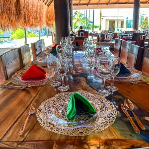 una larga mesa de madera con gafas y servilletas. en Malokas Resort - Socorro - San Gil, en Socorro