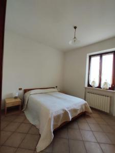 una camera bianca con un letto e due finestre di Azienda Agricola Baldini Ferdinando a Montaperti