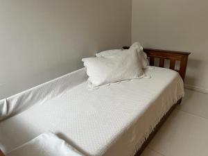 a white bed with white sheets and pillows on it at Departamento con Vista a los cerros con Asador in Yerba Buena