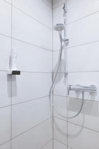 a shower with a shower head in a bathroom at Reos Hotel Isny in Isny im Allgäu