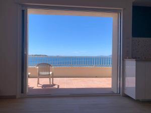 d'une porte coulissante en verre avec une chaise sur le balcon. dans l'établissement Sublime Bord de mer, proche Sanary & Bandol, à Six-Fours-les-Plages