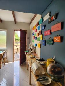 a kitchen with a long counter with signs on the wall at Pousada Estrela Cordel in Fernando de Noronha