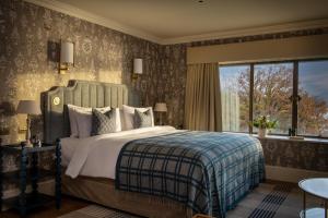 a bedroom with a bed and a large window at Langdale Chase Hotel in Windermere