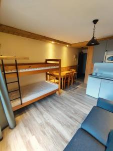 a room with two bunk beds and a table at ski-in ski-out 05 in Val Thorens