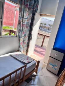 a small bedroom with a bed and a window at Happy Home Dream Surf in Imsouane