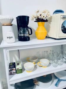 a shelf with cups and a toaster and other items at Cozy 1BR with Patio in the Heart of Albany in Albany