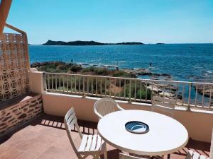 balcón con mesa, sillas y vistas al océano en Sublime Bord de mer, proche Sanary & Bandol, en Six-Fours-les-Plages