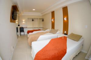 尼泰羅伊的住宿－坎提瑞啦酒店，酒店客房设有三张床和电视。