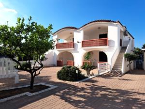 un edificio bianco con un albero di fronte di Villa Vieste a Vieste
