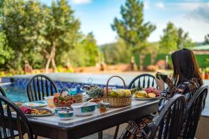 una mujer tomando una foto de una mesa con comida en Malibu Villa by Hill Staytion, en Panchgani