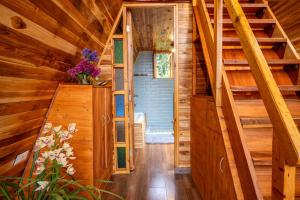 a staircase in a cabin with wooden walls and wooden floors at La Gloria Reserva Forestal in La Calera