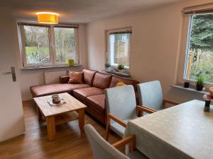 een woonkamer met een bank en een tafel bij Ruhige Ferienwohnung mit Sonnenterrasse und Garten in Binz