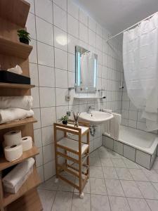 y baño con lavabo, espejo y bañera. en Top of Hostel & Serviced Aparts Deluxe Maisonette-Apart Fürth, en Fürth