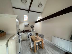 a kitchen with a wooden table and a refrigerator at Barn conversion with hot tub in Lincoln