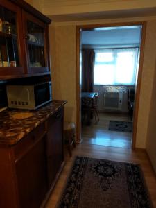 a kitchen with a microwave on a counter and a living room at Бабушкин уют в РУСТАВИ in Rustavi