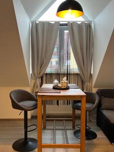 mesa de comedor con 2 sillas y ventana en Top of Hostel & Serviced Aparts Deluxe Maisonette-Apart Fürth, en Fürth
