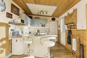 una cocina con electrodomésticos blancos y techos de madera. en The Sea Shack, en Ventnor 34 fotos más