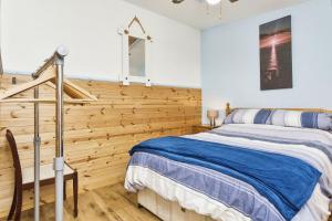 Un dormitorio con una cama y una pared de madera. en The Sea Shack, en Ventnor