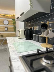 a kitchen with a counter top with a stove at Harrys Home - Weekly & Monthly Offers - Near NEC - Contractors & Business professionals - 2 Parking spaces - 4 Large Bedrooms & 2 Bathrooms - Pool - Table Tennis - Darts - Games console in Wyken