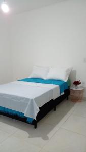 a bed with blue and white sheets in a room at Casa Temporada in Natal +10 photos