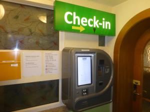 un dispositivo per il check-in su una parete con un cartello verde di ROSSLWIRT-Rast a Strass im Attergau
