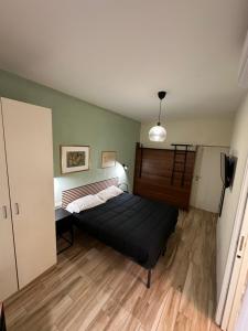 1 dormitorio con cama negra y suelo de madera en B&B Ciruzzo, en Nápoles