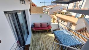 a balcony with a red chair and a window at The 2 bed-Roof terrace-apartment in Málaga