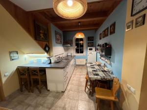 a kitchen with a island and a table with chairs at Pensjonat Malinówka in Szczyrk