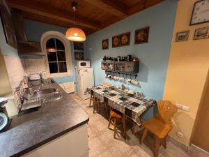 a kitchen with a sink and a table with chairs at Pensjonat Malinówka in Szczyrk +13 photos