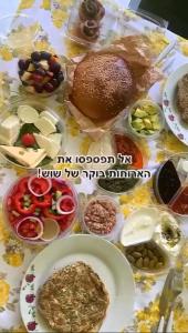 a table topped with plates of food and a hamburger at The Pearl of the Golan - Pnina BaGolan in Had Nes