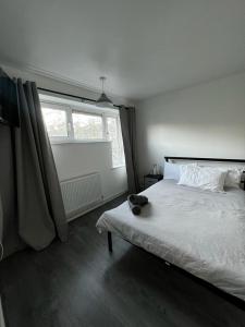 una camera bianca con un letto e una finestra di Holloway Ap a Londra
