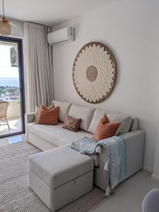 a living room with a couch and a mirror at Seaview serenity apartment in Flic-en-Flac