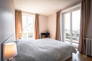 a bedroom with a bed and a large window at Le Chevran - Conciergerie de la Yaute in Cluses