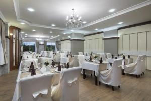 a banquet hall with white tables and white chairs at Aydinbey Gold Dreams in Avsallar