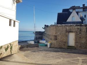 een stenen gebouw met de oceaan op de achtergrond bij Appartement cosy et rénové in Le Pouliguen