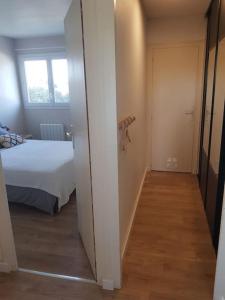 een hal met een bed en een deur naar een slaapkamer bij Appartement cosy et rénové in Le Pouliguen