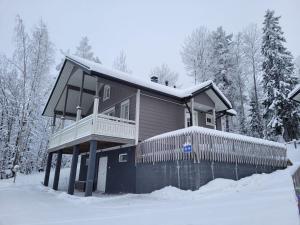 una casa en la nieve con árboles nevados en Villa Magnolia 1 Himos, en Jämsä