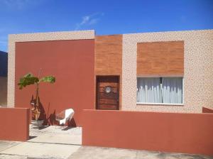 un edificio con una puerta y un árbol delante de él en Linda casa em pequeno condominio! Disponível curtas medias e longas temporadas, en Aracaju