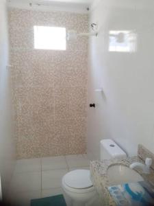 Un baño con ducha, inodoro y lavabo. en Linda casa em pequeno condominio! Disponível curtas medias e longas temporadas, en Aracaju