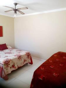 Un dormitorio con una cama y un ventilador de techo. en Linda casa em pequeno condominio! Disponível curtas medias e longas temporadas, en Aracaju